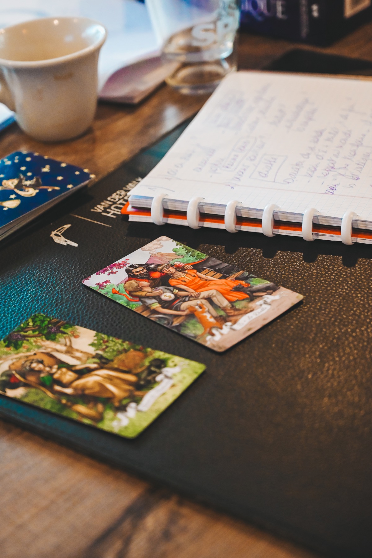 Cahier et cartes disposées sur la table